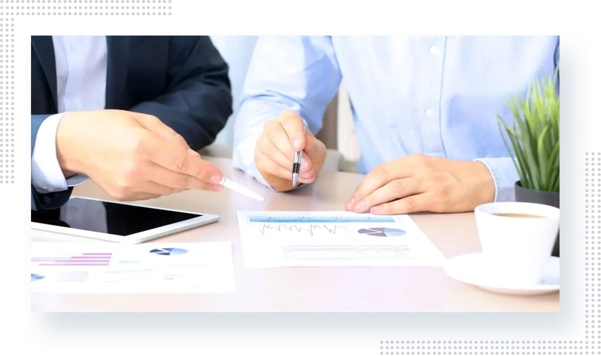 Two people sitting at a table with papers and pens.